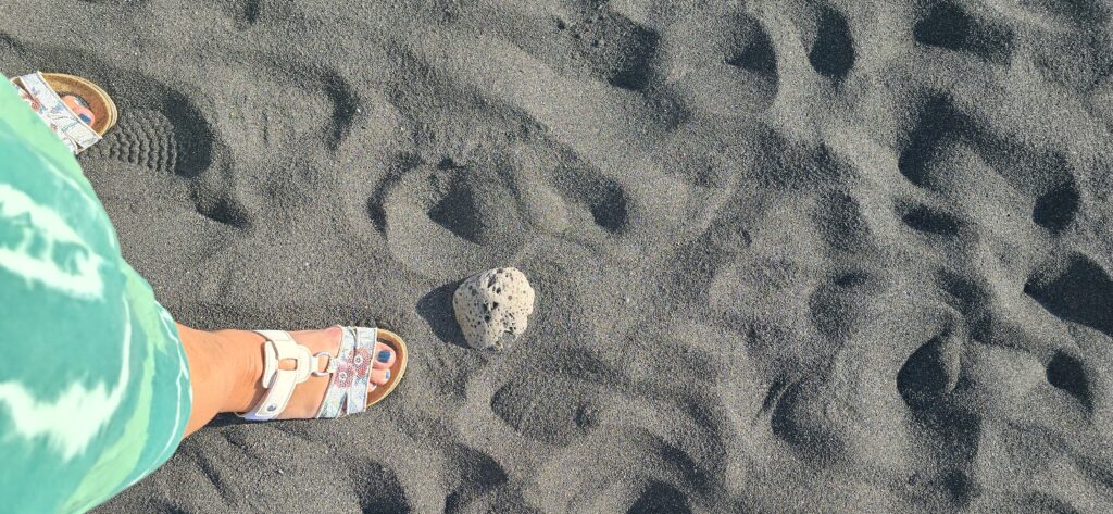 meine Füße im Sand, dazu mein grünes Gewand. Der Sand ist schwarz, und da liegt ein Stein im Weg