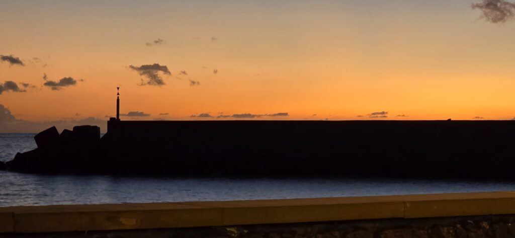 Die schwarze Mole mit dem Leuchtturm vor Sonnenuntergang im Hafen von Tazacorte